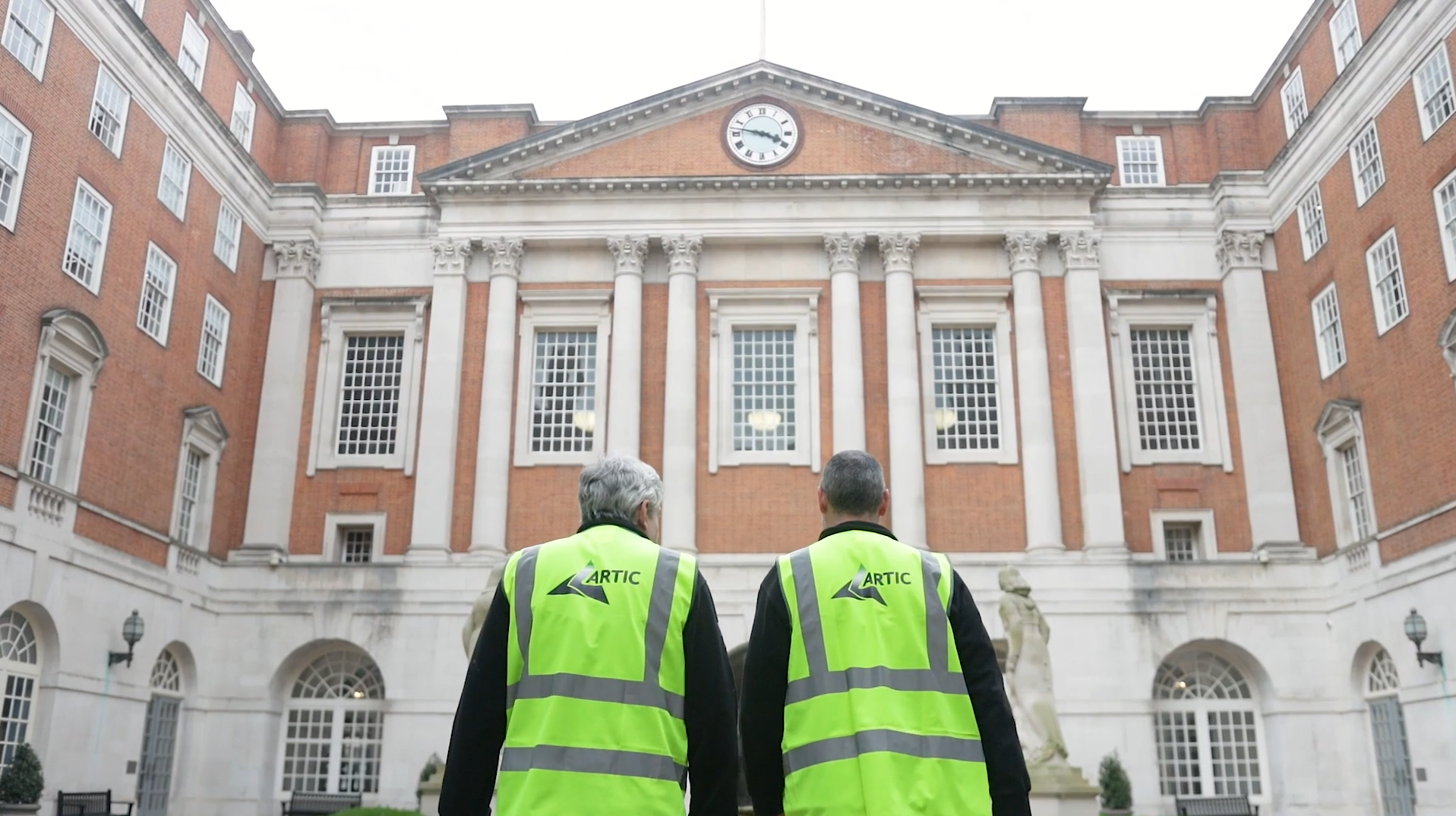 Two Artic engineers standing in front of large building in London